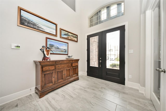 foyer featuring a towering ceiling and french doors