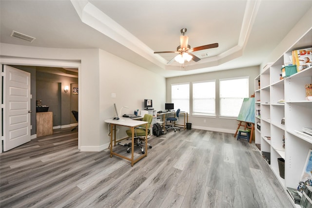 office space with hardwood / wood-style floors, a raised ceiling, and ceiling fan