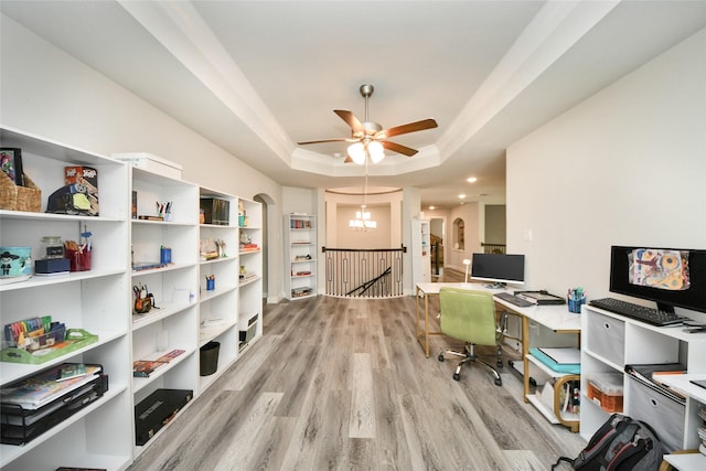 office area featuring ceiling fan with notable chandelier, a tray ceiling, and light hardwood / wood-style floors