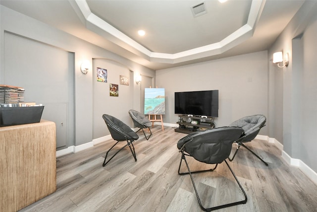 living area featuring a tray ceiling and hardwood / wood-style flooring