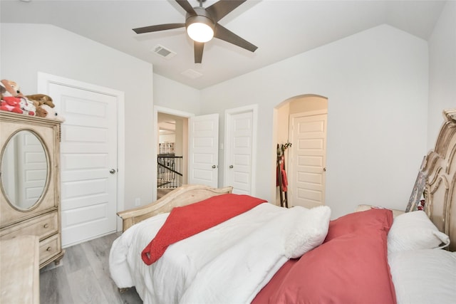 bedroom with ceiling fan, vaulted ceiling, and light hardwood / wood-style flooring