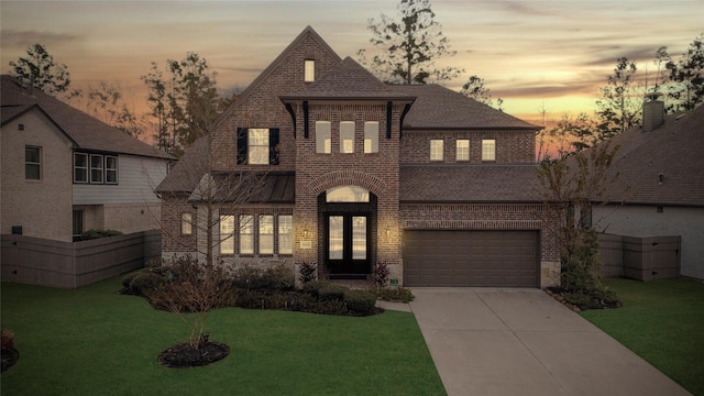 view of front of property featuring a garage and a yard