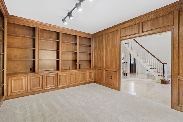 unfurnished living room with light carpet and wood walls