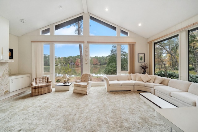 living room featuring a water view, carpet, a wealth of natural light, and lofted ceiling