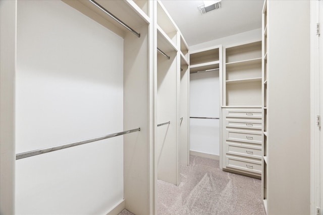 walk in closet featuring light colored carpet