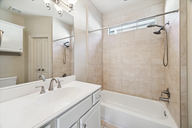 full bathroom with toilet, vanity, and tiled shower / bath