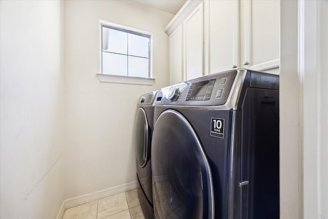 washroom featuring light tile patterned floors, cabinets, and washer and dryer