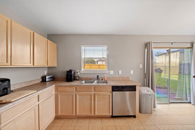 kitchen featuring stainless steel dishwasher, sink, light brown cabinets, light tile patterned floors, and plenty of natural light