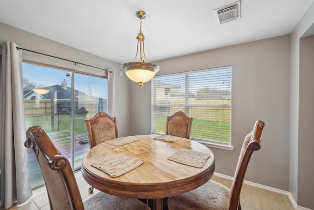 tiled dining room featuring plenty of natural light