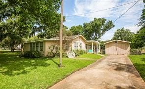 ranch-style home featuring a front yard and a storage shed