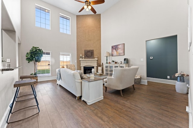 living room featuring hardwood / wood-style floors, a towering ceiling, and ceiling fan