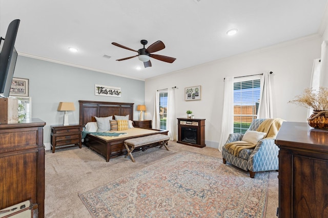 carpeted bedroom with multiple windows, crown molding, a fireplace, and ceiling fan