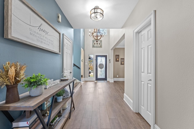 doorway to outside with hardwood / wood-style floors and an inviting chandelier