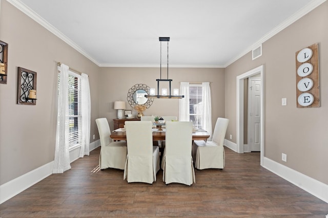 dining room with crown molding, dark hardwood / wood-style floors, and a chandelier