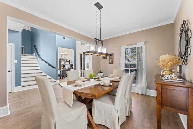 dining space with crown molding, hardwood / wood-style floors, and a chandelier