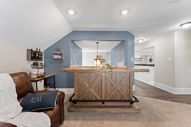 bar featuring hardwood / wood-style floors, lofted ceiling, and pendant lighting