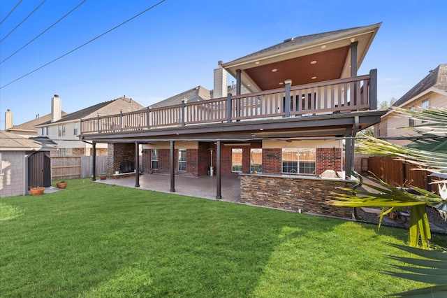 rear view of property featuring a yard, a deck, a shed, and a patio area