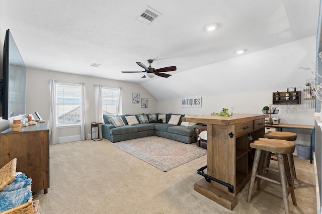 living room with light carpet, a textured ceiling, lofted ceiling, and ceiling fan