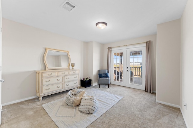 sitting room featuring french doors and light carpet