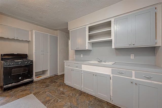 kitchen featuring black gas range, a textured ceiling, and sink