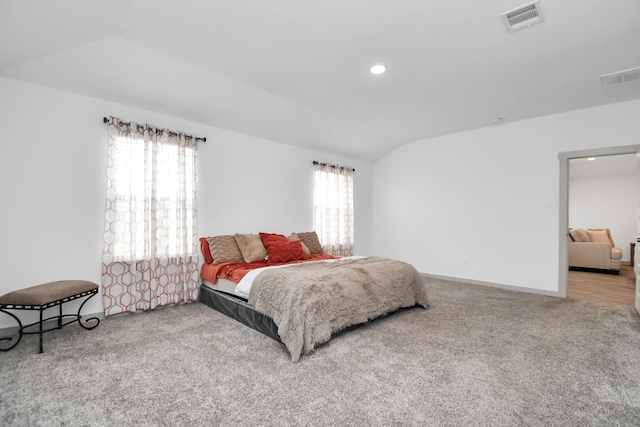 bedroom with carpet flooring, multiple windows, and lofted ceiling