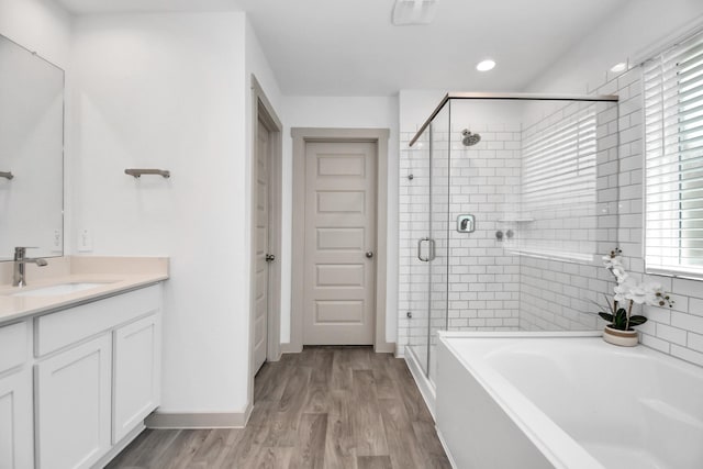 bathroom with separate shower and tub, vanity, and hardwood / wood-style flooring