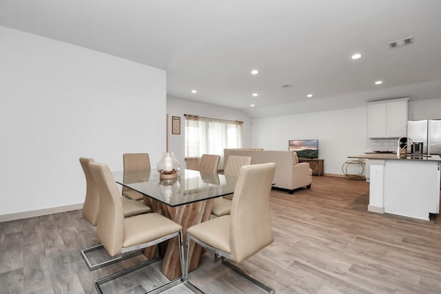 dining space with light hardwood / wood-style flooring