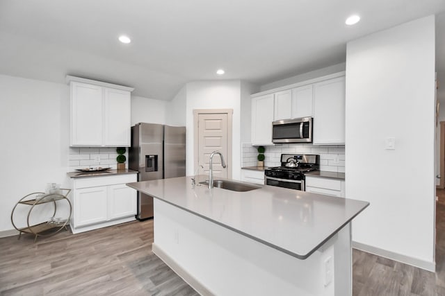 kitchen featuring appliances with stainless steel finishes, an island with sink, white cabinetry, and sink