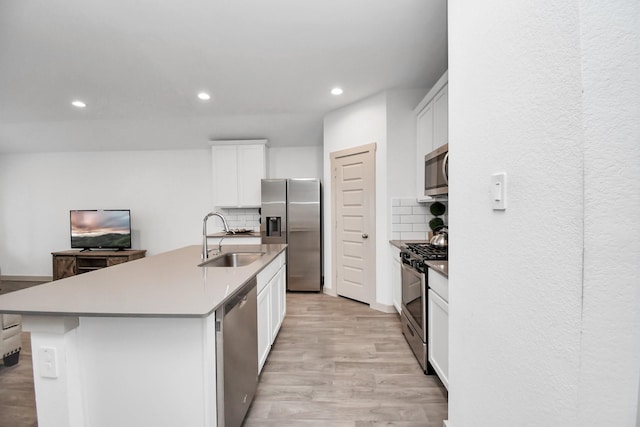 kitchen featuring white cabinets, sink, a kitchen island with sink, and stainless steel appliances