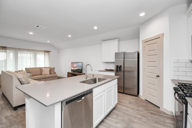 kitchen featuring white cabinetry, sink, an island with sink, decorative backsplash, and appliances with stainless steel finishes