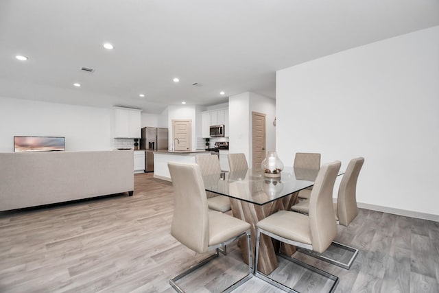 dining room featuring light wood-type flooring and sink