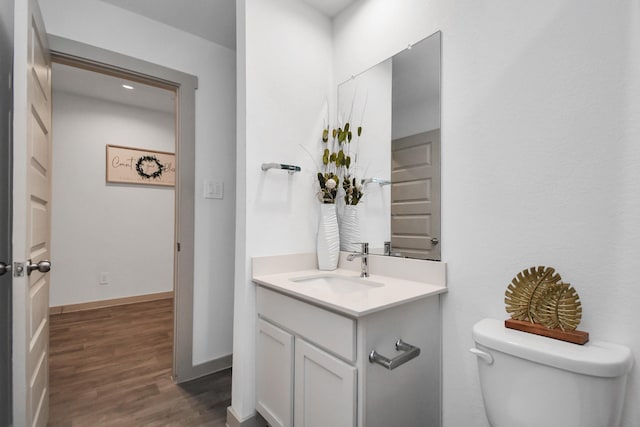 bathroom with vanity, wood-type flooring, and toilet