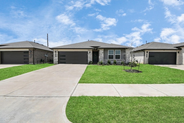 prairie-style home featuring a garage and a front lawn