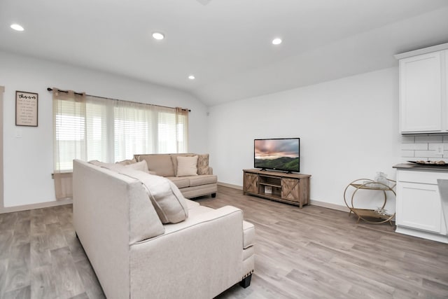 living room with vaulted ceiling and light hardwood / wood-style flooring