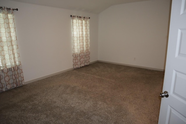 spare room with carpet floors and lofted ceiling