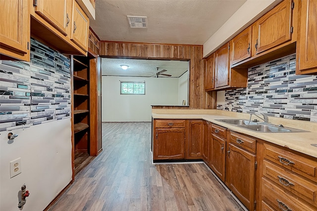 kitchen featuring ceiling fan, sink, hardwood / wood-style floors, and a textured ceiling