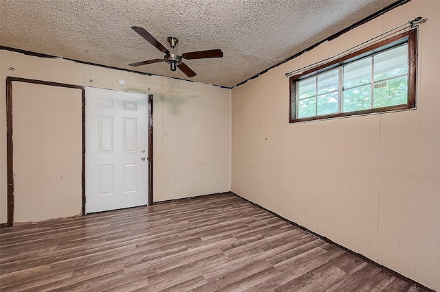 empty room featuring ceiling fan, light hardwood / wood-style floors, and a textured ceiling