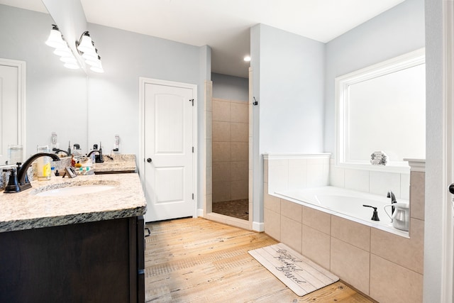 bathroom featuring a bath, a shower stall, vanity, and wood finished floors