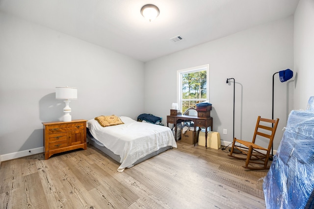 bedroom featuring visible vents, light wood-type flooring, and baseboards