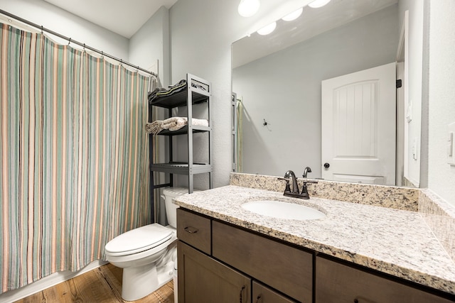 bathroom featuring curtained shower, toilet, wood finished floors, and vanity