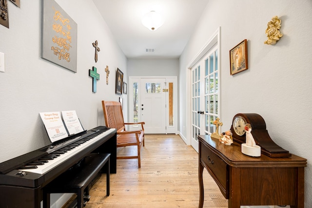 hallway featuring light wood finished floors and visible vents