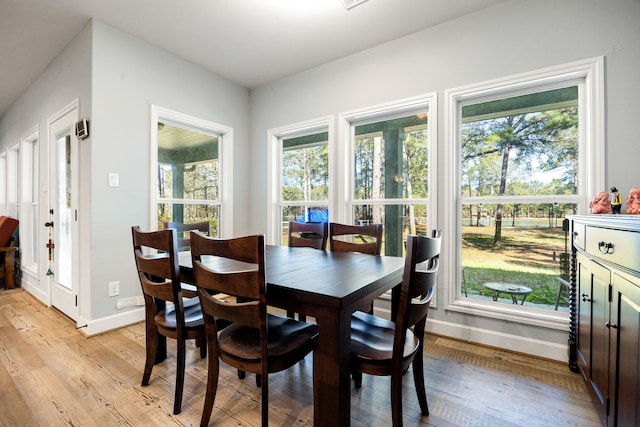 dining space featuring baseboards and light wood-style floors