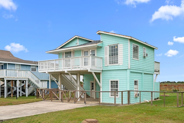 rear view of property with covered porch and a lawn