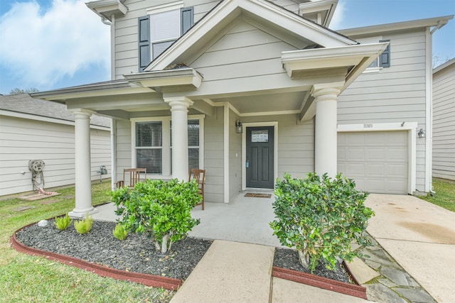 doorway to property featuring a porch and a garage