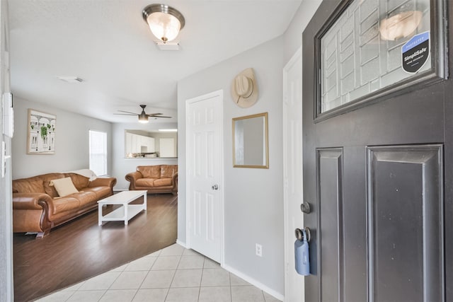 tiled foyer with ceiling fan