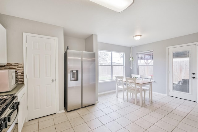 kitchen featuring stainless steel appliances, white cabinetry, and light tile patterned flooring