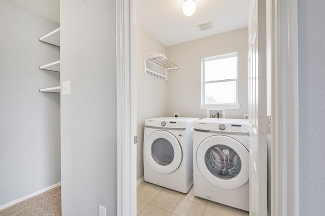 washroom featuring light tile patterned floors and washer and clothes dryer