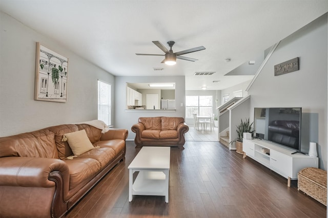 living room featuring ceiling fan, a healthy amount of sunlight, and dark hardwood / wood-style flooring