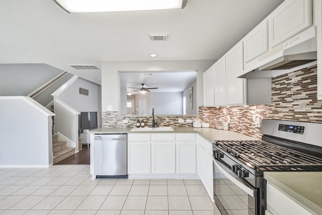 kitchen featuring custom exhaust hood, sink, white cabinetry, and stainless steel appliances