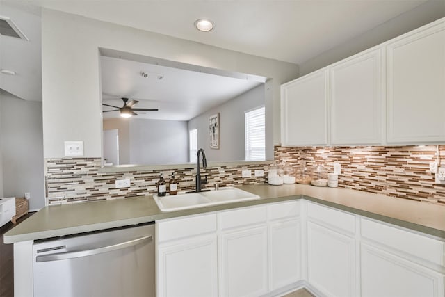 kitchen with kitchen peninsula, white cabinetry, dishwasher, and sink